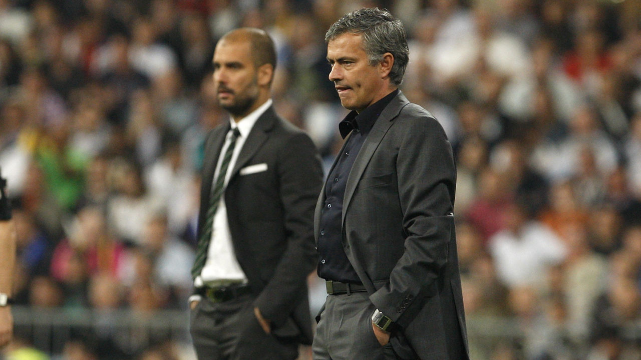 MADRID, SPAIN - APRIL 16: Head coach Jose Mourinho (R) of Real Madrid looks on backdropped by head coach Josep Guardiola of Barcelona during the La Liga match between Real Madrid and Barcelona at Estadio Santiago Bernabeu on April 16, 2011 in Madrid, Spain.