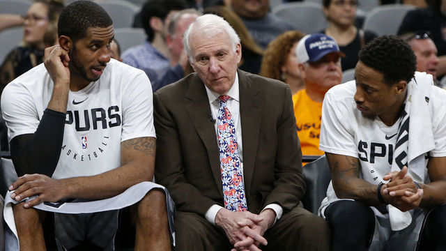 SAN ANTONIO, TX - NOVEMBER 30: Gregg Popovich head coach of the San Antonio Spurs talks with players Pau Gasol #16, LaMarcus Aldridge #12, and DeMar DeRozan #10 on the bench during an NBA game against the Houston Rockets held November 30, 2018 at the AT&T Center in San Antonio, Texas. The Houston Rockets won 136-105.