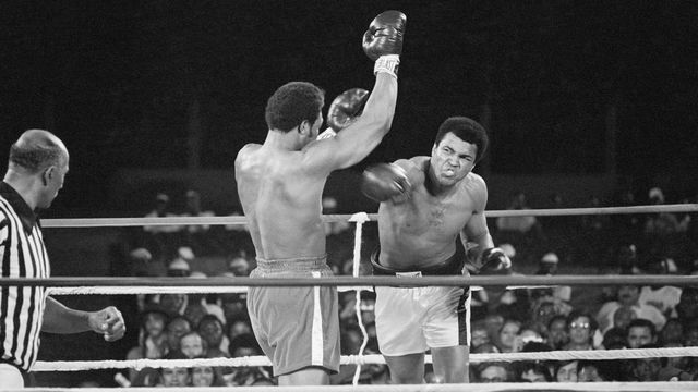 Muhammad Ali (r) punches George Foreman (c) during their world heavyweight title boxing match in 1974, while a referee looks on.