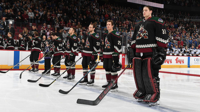 GLENDALE, AZ - DECEMBER 01: Goalie Adin Hill #31 and Nick Cousins #25 of the Arizona Coyotes stand on the blue line with teammates prior to a game against the St Louis Blues at Gila River Arena on December 1, 2018 in Glendale, Arizona.