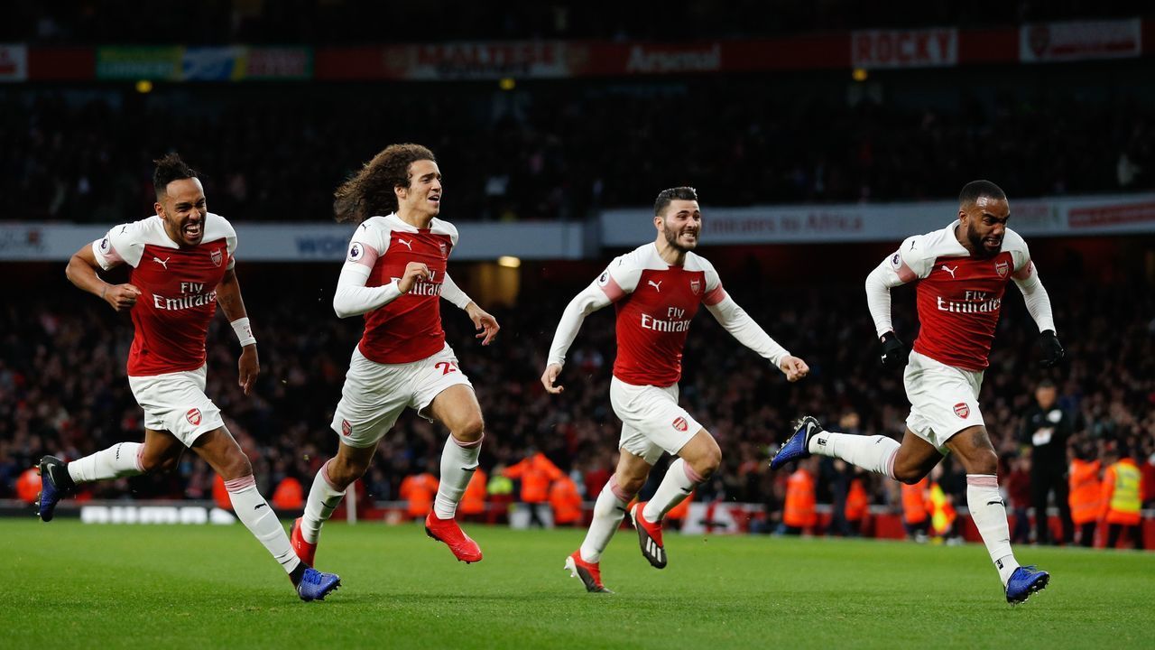 Arsenal's French striker Alexandre Lacazette (R) celebrates with teammates after scoring their third goal during the English Premier League football match between Arsenal and Tottenham Hotspur at the Emirates Stadium in London on December 2, 2018.