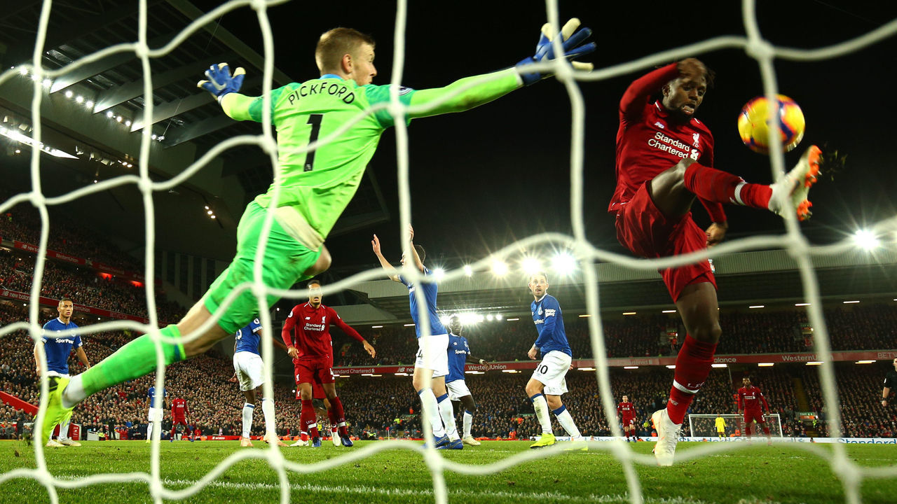 LIVERPOOL, ENGLAND - DECEMBER 02: Divock Origi of Liverpool shoots and misses as Jordan Pickford of Everton reaches for the ball during the Premier League match between Liverpool FC and Everton FC at Anfield on December 2, 2018 in Liverpool, United Kingdom.
