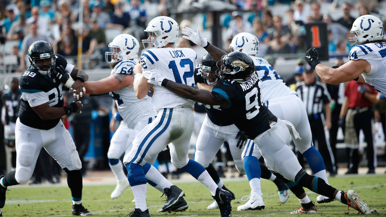 JACKSONVILLE, FL - DECEMBER 02: Andrew Luck #12 of the Indianapolis Colts is pressured by Yannick Ngakoue #91 of the Jacksonville Jaguars during A game at TIAA Bank Field on December 2, 2018 in Jacksonville, Florida.