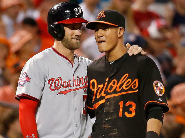 BALTIMORE, MD - JULY 10: Bryce Harper #34 of the Washington Nationals and Manny Machado #13 of the Baltimore Orioles talk during their game at Oriole Park at Camden Yards on July 10, 2015 in Baltimore, Maryland.