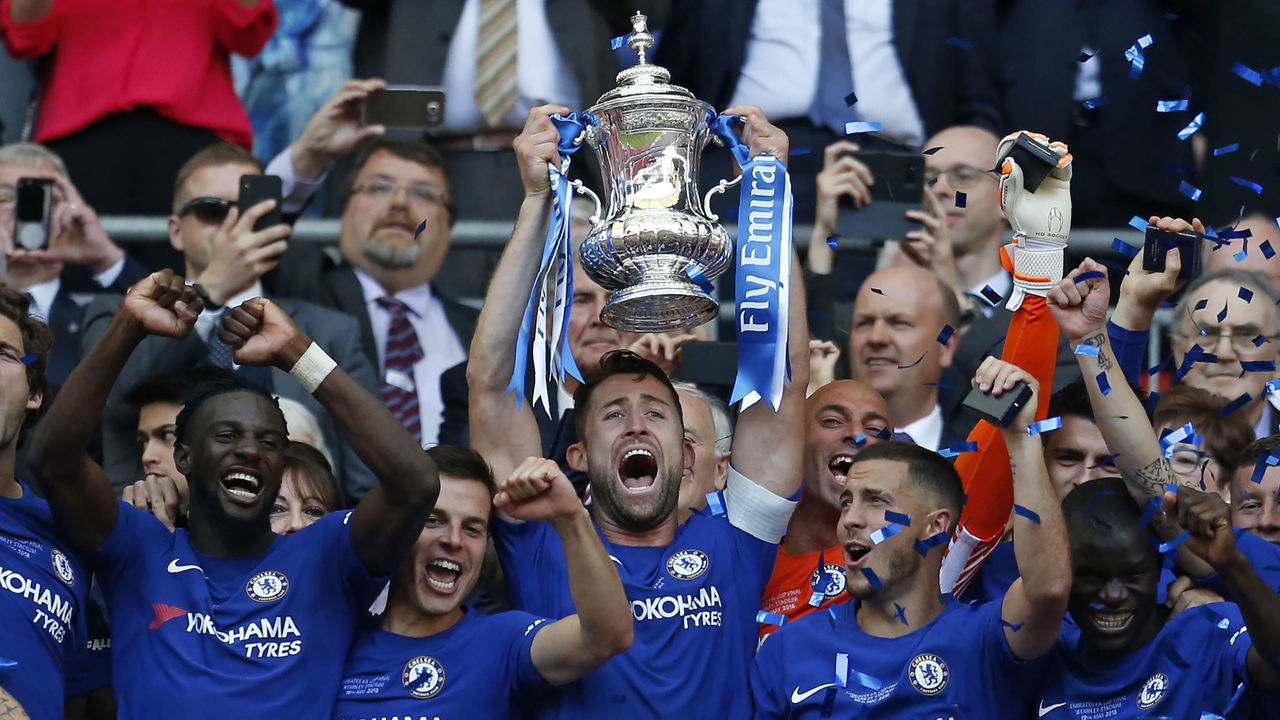 TOPSHOT - Chelsea's English defender Gary Cahill lifts the trophy as Chelsea players celebrate their win after the English FA Cup final football match between Chelsea and Manchester United at Wembley stadium in London on May 19, 2018. - Chelsea won the game 1-0.