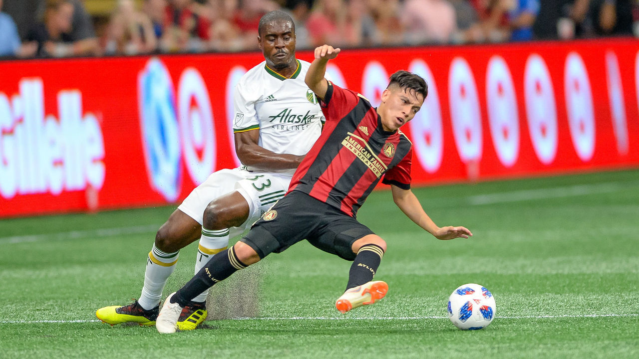 ATLANTA, GA - JUNE 24: Atlanta United midfielder Ezequiel Barco (8) is taken down by Portland Timbers defender Larrys Mabiala (33) during a MLS match between the Portland Timbers and Atlanta United on June 24, 2018, at Mercedes-Benz Stadium in Atlanta, GA.