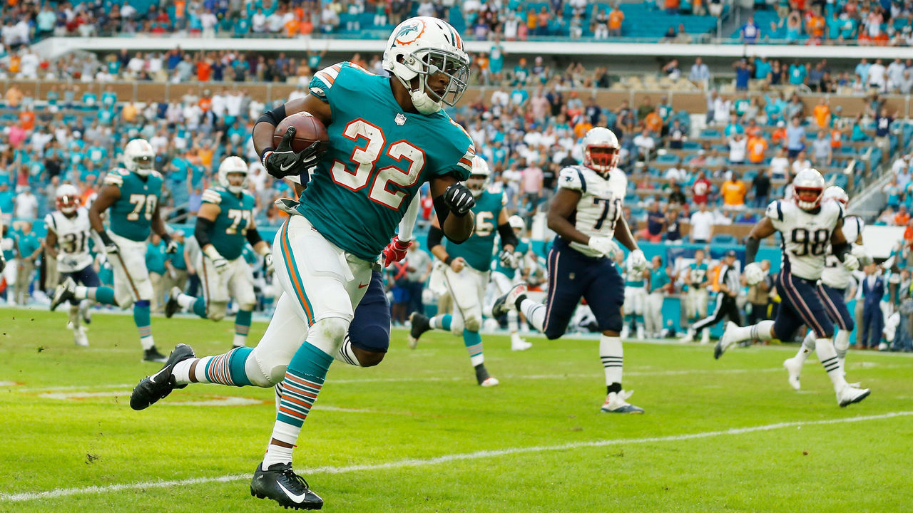 MIAMI, FL - DECEMBER 09: Kenyan Drake #32 of the Miami Dolphins carries the ball for the game winning touchdown defeating the New England Patriots 34-33 at Hard Rock Stadium on December 9, 2018 in Miami, Florida.