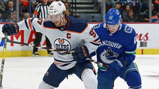 VANCOUVER, BC - DECEMBER 17: Adam Gaudette #88 of the Vancouver Canucks checks Connor McDavid #97 of the Edmonton Oilers during their NHL game at Rogers Arena December 17, 2018 in Vancouver, British Columbia, Canada.