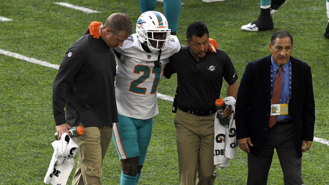 MINNEAPOLIS, MN - DECEMBER 16: Frank Gore #21 of the Miami Dolphins is helped off the field by team trainers in the second quarter of the game against the Minnesota Vikings at U.S. Bank Stadium on December 16, 2018 in Minneapolis, Minnesota.