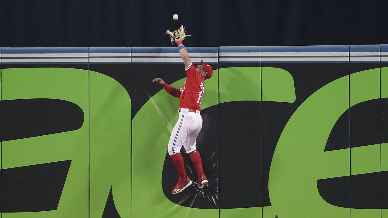 TORONTO, ON - JULY 1: Kevin Pillar #11 of the Toronto Blue Jays climbs the wall and catches a fly ball hit by Nicholas Castellanos #9 of the Detroit Tigers in the ninth inning during MLB game action at Rogers Centre on July 1, 2018 in Toronto, Canada.