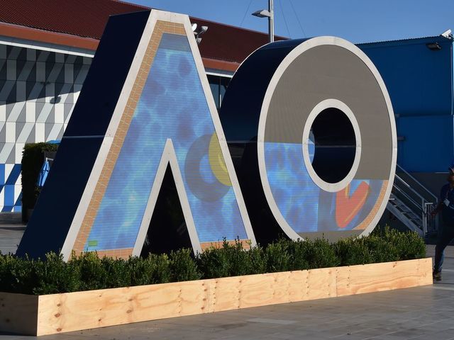A worker checks on a logo for the Australian Open tennis tournament ahead of its start in Melbourne on January 14, 2018. / AFP PHOTO / PETER PARKS / -- IMAGE RESTRICTED TO EDITORIAL USE - STRICTLY NO COMMERCIAL USE --