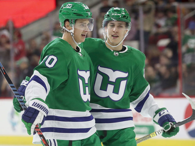 RALEIGH, NC - DECEMBER 23: Sebastian Aho #20 of the Carolina Hurricanes celebrates with teammate Teuvo Teravainen #86 after scoring a goal during an NHL game against the Boston Bruins on December 23, 2018 at PNC Arena in Raleigh, North Carolina.