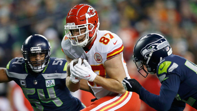 SEATTLE, WA - DECEMBER 23: Travis Kelce #87 of the Kansas City Chiefs tries to get past Bobby Wagner #54 (L) and Delano Hill #42 (R) of the Seattle Seahawks during the second quarter of the game at CenturyLink Field on December 23, 2018 in Seattle, Washington.