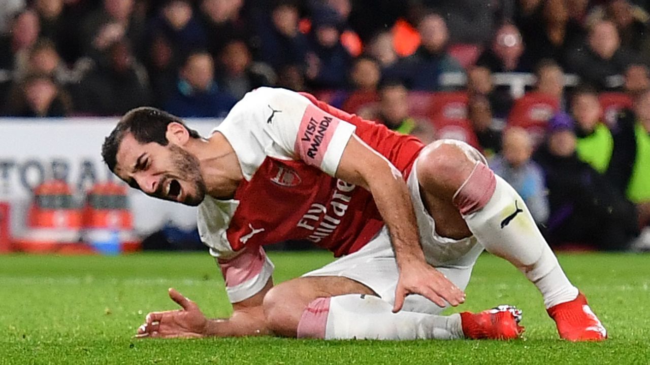 Arsenal's Armenian midfielder Henrikh Mkhitaryan takes a knock needing attention on the field during the English League Cup quarter-final football match between Arsenal and Tottenham Hotspur at the Emirates Stadium in London on December 19, 2018.