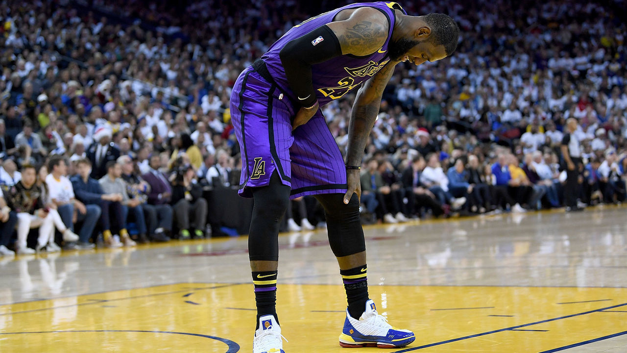 OAKLAND, CA - DECEMBER 25: LeBron James #23 of the Los Angeles Lakers leans over in pain after he was hurt against the Golden State Warriors during the second half of their NBA Basketball game at ORACLE Arena on December 25, 2018 in Oakland, California.