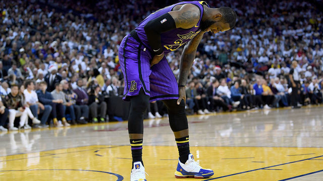 OAKLAND, CA - DECEMBER 25: LeBron James #23 of the Los Angeles Lakers leans over in pain after he was hurt against the Golden State Warriors during the second half of their NBA Basketball game at ORACLE Arena on December 25, 2018 in Oakland, California.