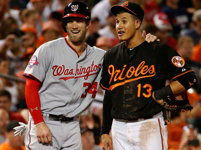 BALTIMORE, MD - JULY 10: Bryce Harper #34 of the Washington Nationals and Manny Machado #13 of the Baltimore Orioles talk during their game at Oriole Park at Camden Yards on July 10, 2015 in Baltimore, Maryland.
