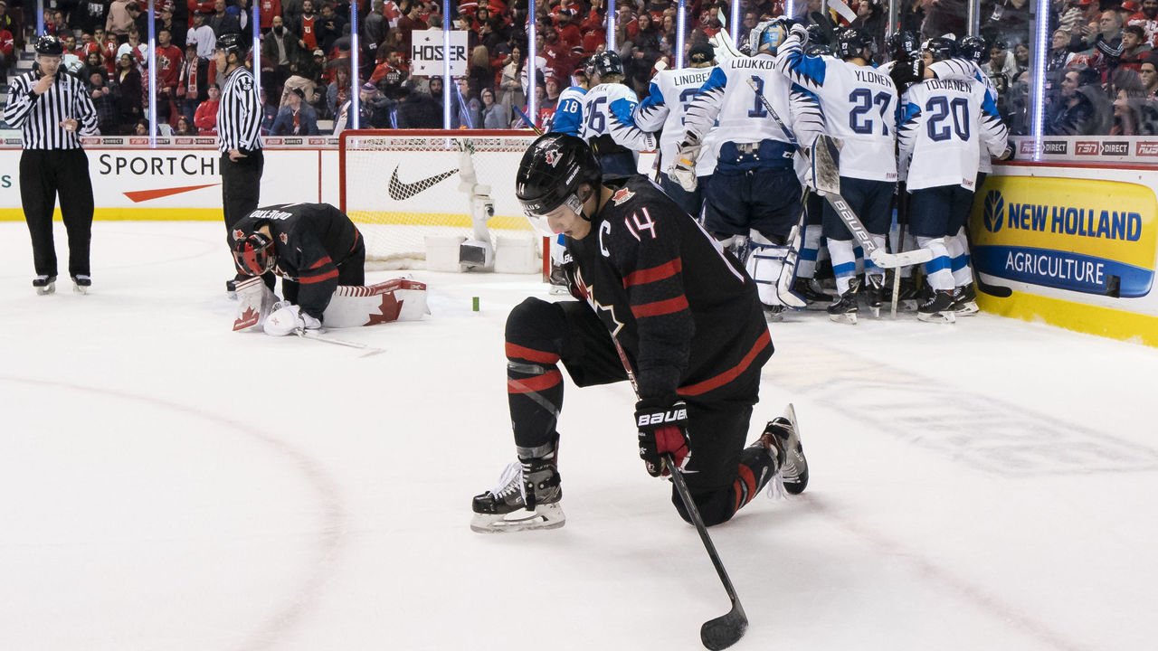 VANCOUVER, BC - JANUARY 2: Maxime Comtois #14 and goalie Michael Dipietro #1 of Canada kneels on the ice as Finland celebrates after winning 2-1 in overtime in Quarterfinal hockey action of the 2019 IIHF World Junior Championship on January, 2, 2019 at Rogers Arena in Vancouver, British Columbia, Canada.