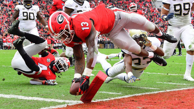 ATHENS, GA - NOVEMBER 24: Elijah Holyfield #13 of the Georgia Bulldogs scores a second quarter touchdown against the Georgia Tech Yellow Jackets on November 24, 2018 at Sanford Stadium in Athens, Georgia.