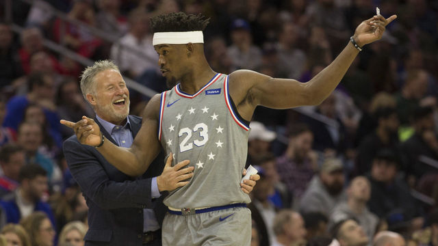 PHILADELPHIA, PA - NOVEMBER 30: Head coach Brett Brown of the Philadelphia 76ers shares a laugh with Jimmy Butler #23 in the third quarter against the Washington Wizards at the Wells Fargo Center on November 30, 2018 in Philadelphia, Pennsylvania. The 76ers defeated the Wizards 123-98.