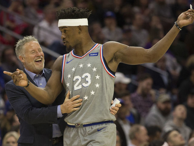 PHILADELPHIA, PA - NOVEMBER 30: Head coach Brett Brown of the Philadelphia 76ers shares a laugh with Jimmy Butler #23 in the third quarter against the Washington Wizards at the Wells Fargo Center on November 30, 2018 in Philadelphia, Pennsylvania. The 76ers defeated the Wizards 123-98.
