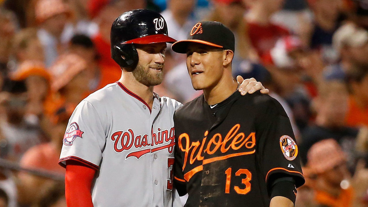 BALTIMORE, MD - JULY 10: Bryce Harper #34 of the Washington Nationals and Manny Machado #13 of the Baltimore Orioles talk during their game at Oriole Park at Camden Yards on July 10, 2015 in Baltimore, Maryland.