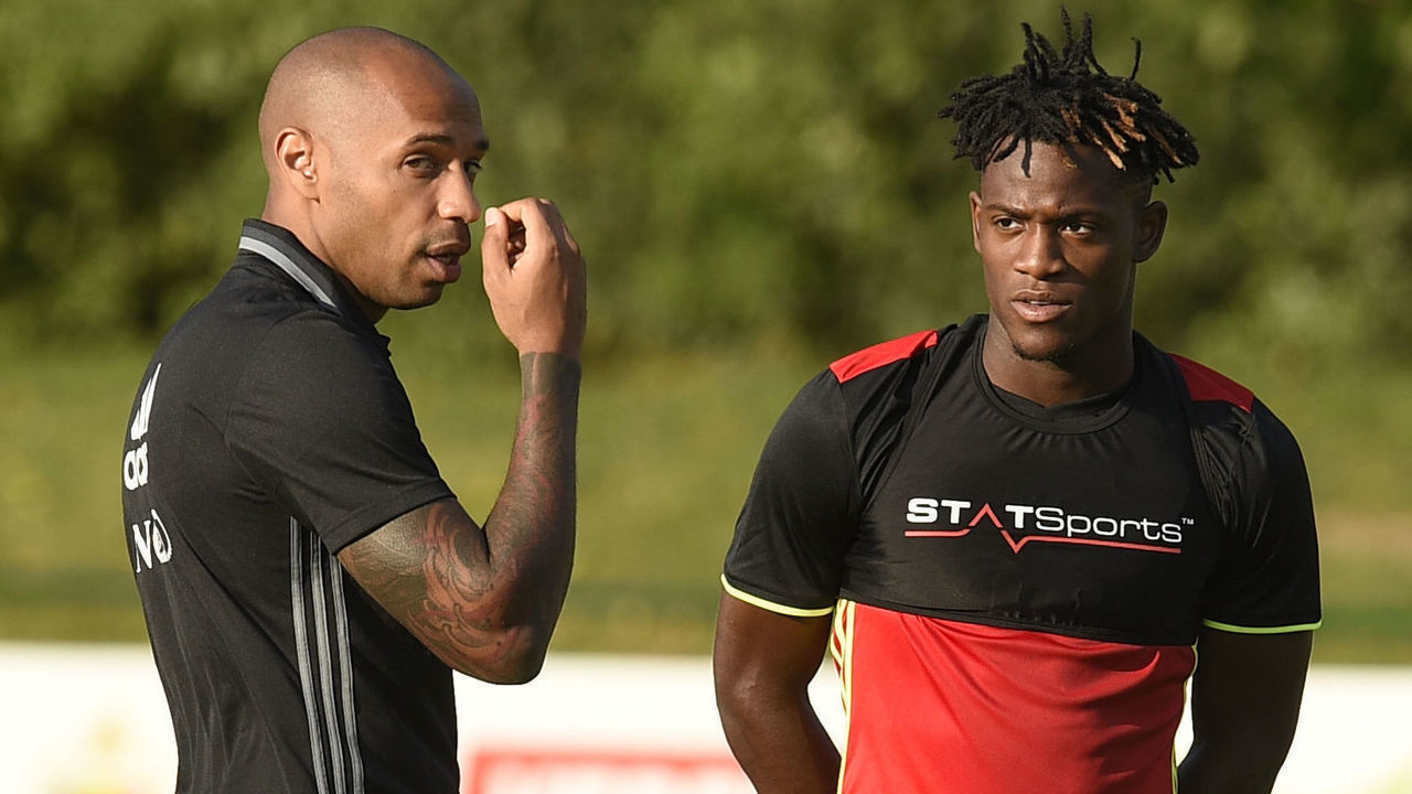 Belgium's national team assistant coach Thierry Henry (L) gestures as he talks with Belgium's forward Michy Batshuayi during a training session, three days before their football match against Spain, in Neerpede on August 29, 2016. / AFP / JOHN THYS