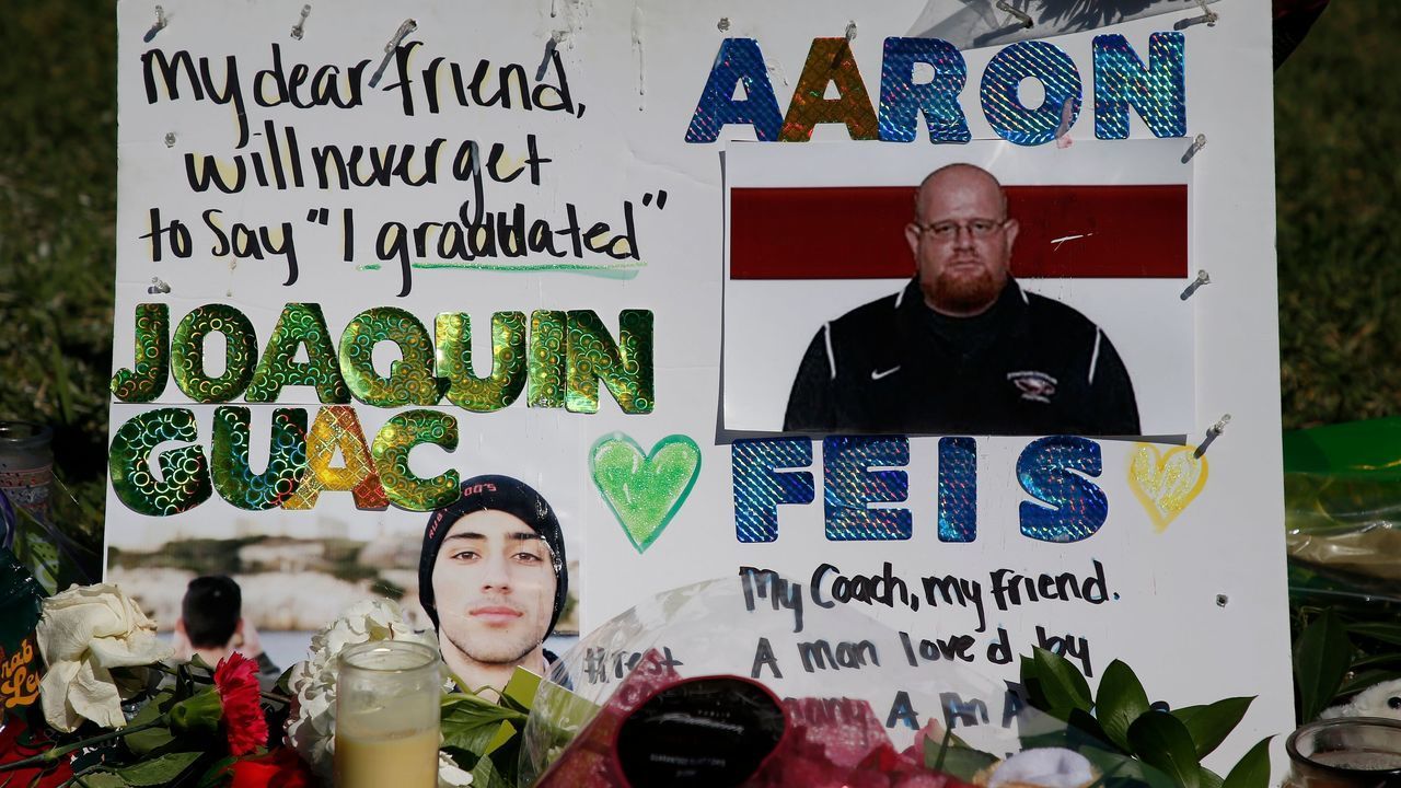 A memorial for student Joaquin Oliver and assistant football coach Aaron Feis, two of the victims of the Marjory Stoneman Douglas High School shooting, sits in a park in Parkland, Florida on February 16, 2018. A former student, Nikolas Cruz, opened fire at the Florida high school leaving 17 people dead and 15 injured. / AFP PHOTO / RHONA WISE
