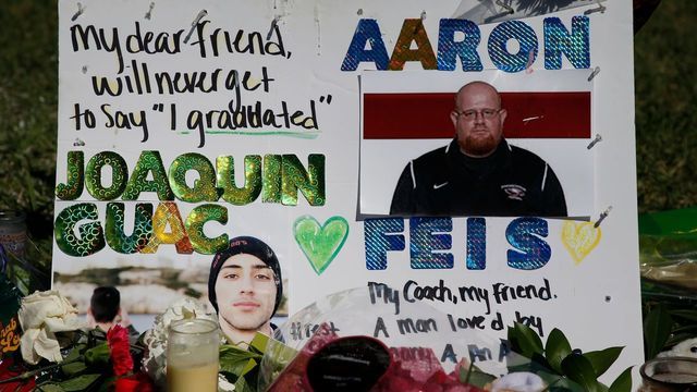 A memorial for student Joaquin Oliver and assistant football coach Aaron Feis, two of the victims of the Marjory Stoneman Douglas High School shooting, sits in a park in Parkland, Florida on February 16, 2018. A former student, Nikolas Cruz, opened fire at the Florida high school leaving 17 people dead and 15 injured. / AFP PHOTO / RHONA WISE
