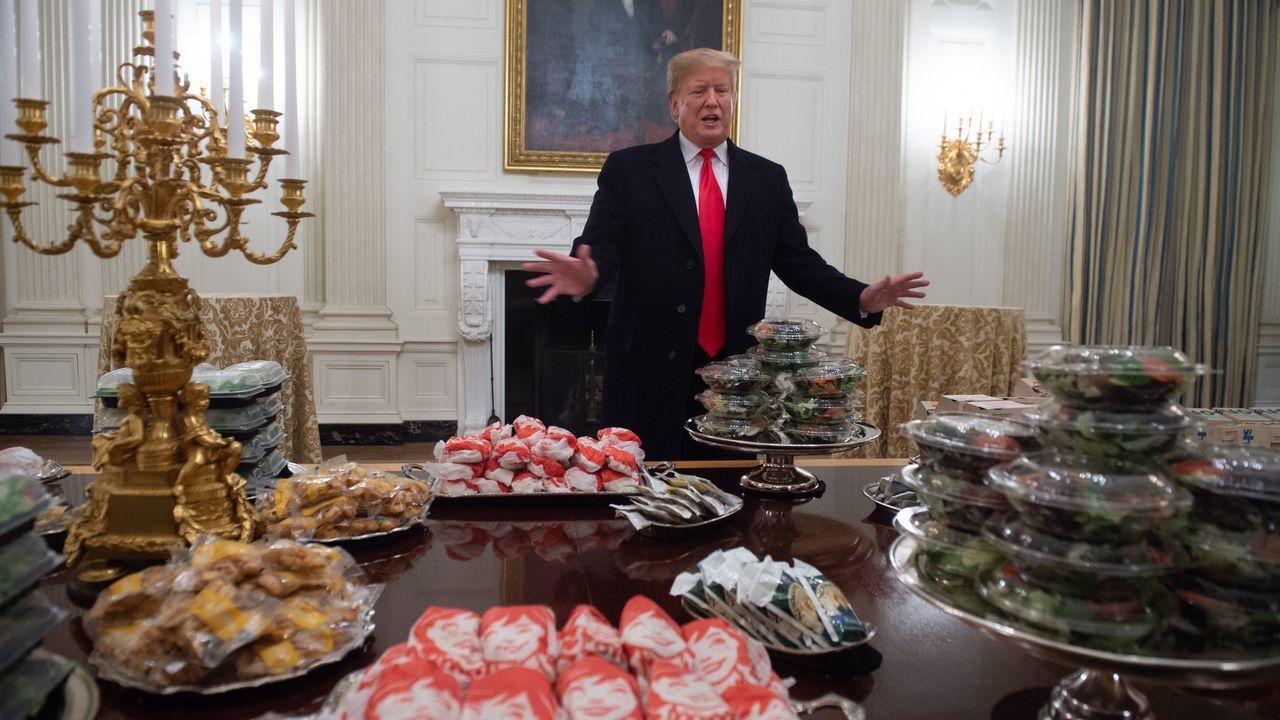 US President Donald Trump speaks alongside fast food he purchased for a ceremony honoring the 2018 College Football Playoff National Champion Clemson Tigers in the State Dining Room of the White House in Washington, DC, January 14, 2019. - Trump says the White House chefs are furloughed due to the partial government shutdown.