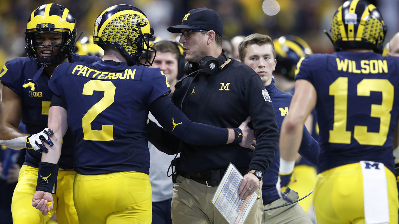 ATLANTA, GA - DECEMBER 29: Head coach Jim Harbaugh of the Michigan Wolverines talks to Shea Patterson #2 during the Chick-fil-A Peach Bowl against the Florida Gators at Mercedes-Benz Stadium on December 29, 2018 in Atlanta, Georgia. Florida won 41-15.