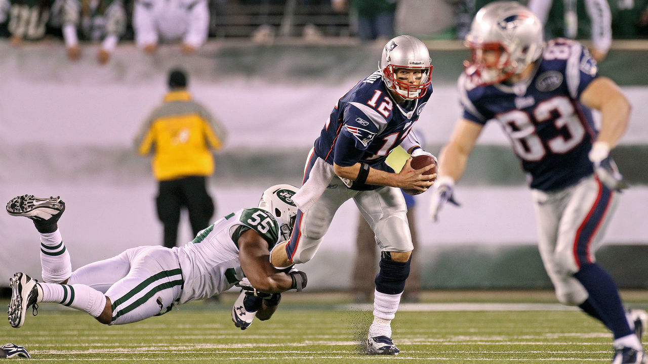 EAST RUTHERFORD - NOVEMBER 13: Patriots quarterback Tom Brady escapes the grasp of the Jets Jamal Washington, as Wes Welker tries to get open at right in the second quarter. The New England Patriots visited the New York Jets in a regular season NFL game at MetLife Stadium.