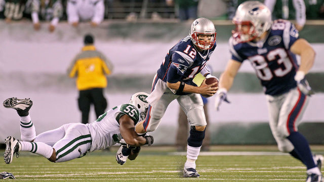 EAST RUTHERFORD - NOVEMBER 13: Patriots quarterback Tom Brady escapes the grasp of the Jets Jamal Washington, as Wes Welker tries to get open at right in the second quarter. The New England Patriots visited the New York Jets in a regular season NFL game at MetLife Stadium.