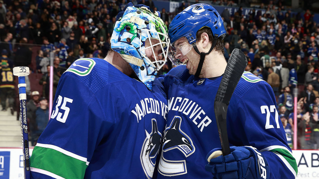 VANCOUVER, BC - JANUARY 18: Thatcher Demko #35 of the Vancouver Canucks is congratulated by teammate Ben Hutton #27 after their NHL game against the Buffalo Sabres at Rogers Arena January 18, 2019 in Vancouver, British Columbia, Canada. Vancouver won 4-3.