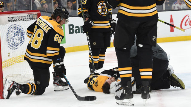 BOSTON, MA - JANUARY 19: David Pastrnak #88 looks on as team mate Tuukka Rask #40 of the Boston Bruins gets checked out by team doctor during the game against the New York Rangers at the TD Garden on January 19, 2019 in Boston, Massachusetts.