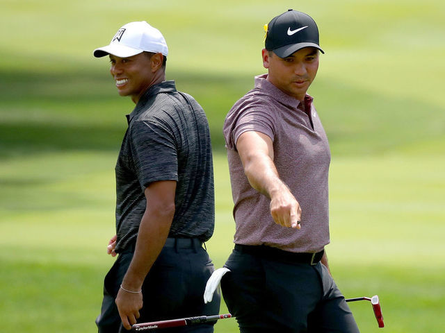 AKRON, OH - AUGUST 03: Jason Day of Australia lines up a putt as Tiger Woods walks by on the third green during World Golf Championships-Bridgestone Invitational - Round Two at Firestone at Firestone Country Club South Course on August 3, 2018 in Akron, Ohio.