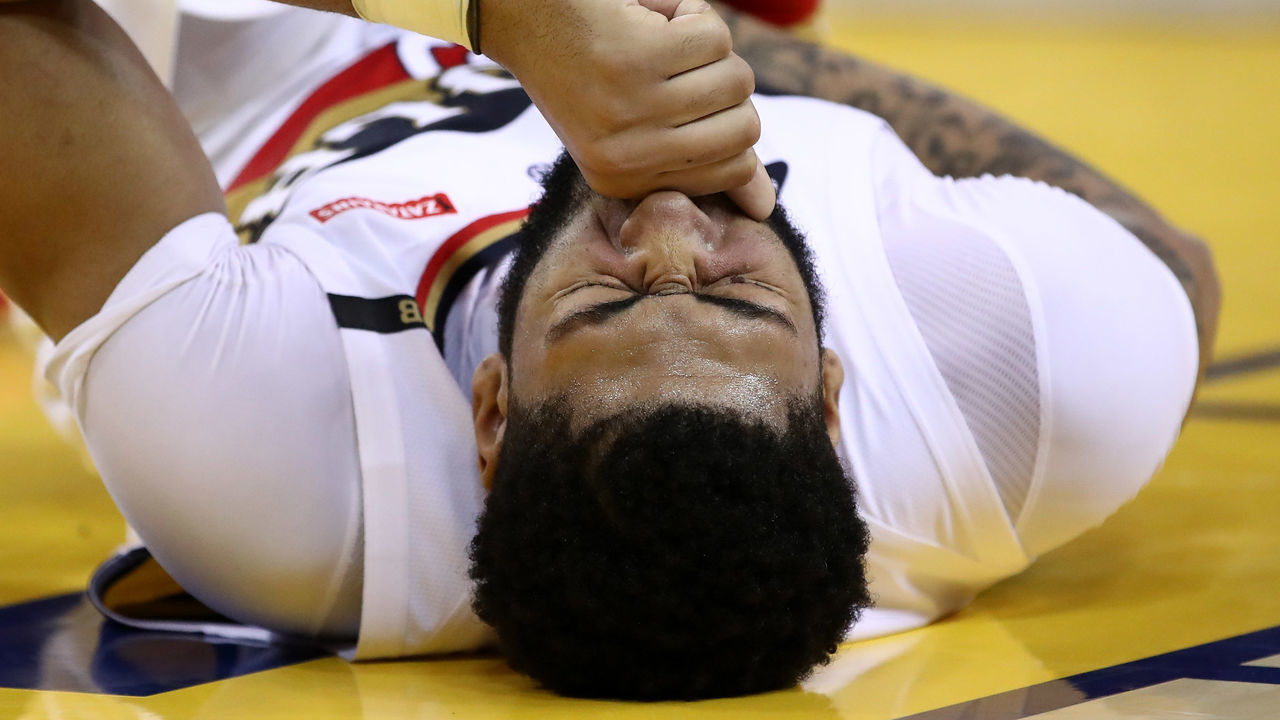 OAKLAND, CALIFORNIA - JANUARY 16: Anthony Davis #23 of the New Orleans Pelicans grimaces after being injured during their game against the Golden State Warriors at ORACLE Arena on January 16, 2019 in Oakland, California.