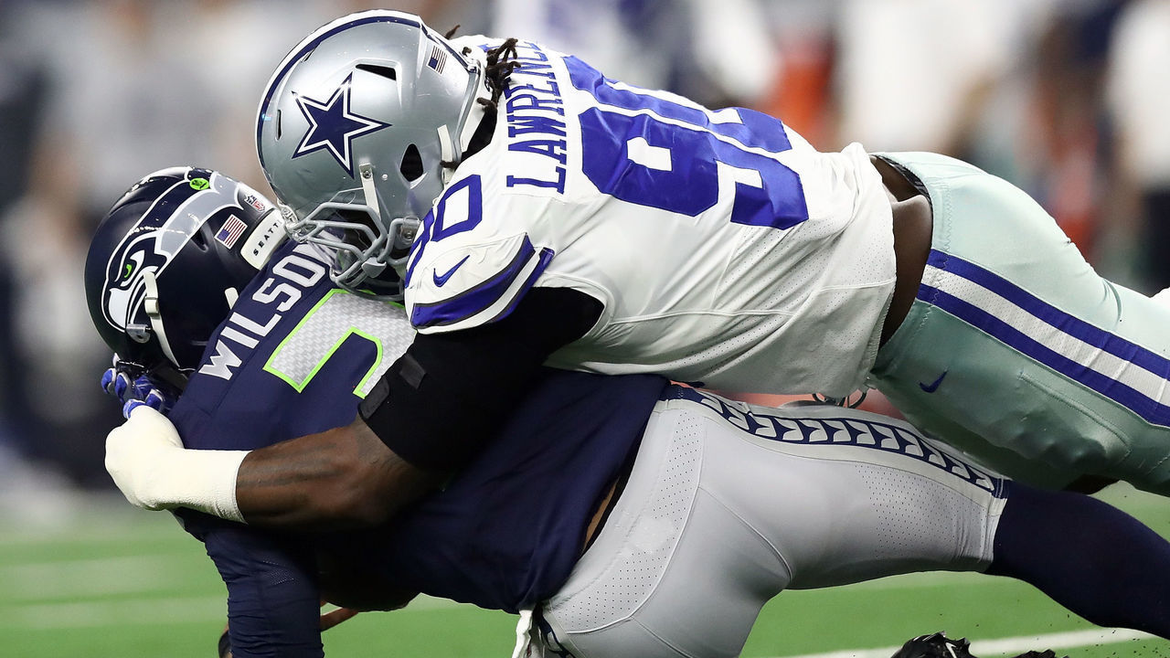 ARLINGTON, TEXAS - JANUARY 05: Russell Wilson #3 of the Seattle Seahawks is sacked by Demarcus Lawrence #90 of the Dallas Cowboys in the first half during the Wild Card Round at AT&T Stadium on January 05, 2019 in Arlington, Texas.