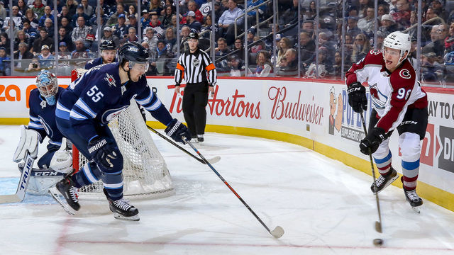 WINNIPEG, MB - JANUARY 8: Mikko Rantanen #96 of the Colorado Avalanche plays the puck along the boards as Mark Scheifele #55 of the Winnipeg Jets defends during first period action at the Bell MTS Place on January 8, 2019 in Winnipeg, Manitoba, Canada.
