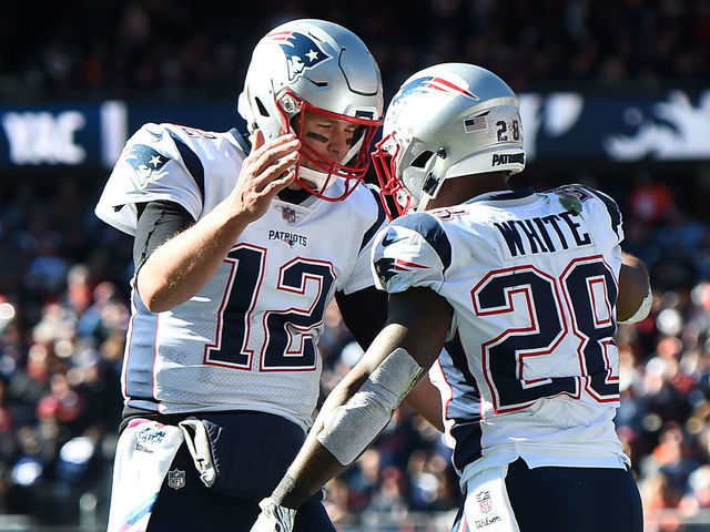 CHICAGO, IL - OCTOBER 21: Quarterback Tom Brady #12 of the New England Patriots and James White #28 celebrate after White scored against the Chicago Bears in the second quarter at Soldier Field on October 21, 2018 in Chicago, Illinois.