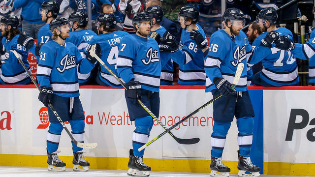 WINNIPEG, MB - JANUARY 11: Blake Wheeler #26, Ben Chiarot #7 and Kyle Connor #81 of the Winnipeg Jets celebrate a first period goal against the Detroit Red Wings with teammates at the bench at the Bell MTS Place on January 11, 2019 in Winnipeg, Manitoba, Canada.