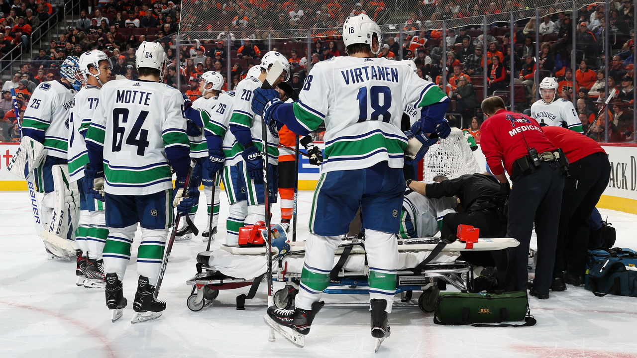 PHILADELPHIA, PA - FEBRUARY 04: Alexander Edler #23 of the Vancouver Canucks(kneeling on ice) is tended to by both teams' medical staff and emergency personnel after being injured in the third period against the Philadelphia Flyers on February 4, 2019 at the Wells Fargo Center in Philadelphia, Pennsylvania. The Flyers went on to defeat the Canucks 2-1. Tonight's win is the 2,000th in Flyers franchise history.
