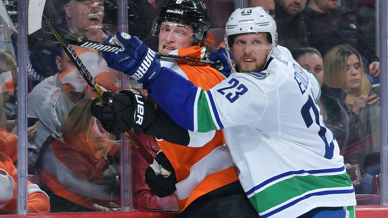 PHILADELPHIA, PENNSYLVANIA - FEBRUARY 04: Alexander Edler #23 of the Vancouver Canucks checks Travis Sanheim #6 of the Philadelphia Flyers during the second period at Wells Fargo Center on February 04, 2019 in Philadelphia, Pennsylvania.