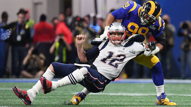 ATLANTA, GA - FEBRUARY 03: Tom Brady #12 of the New England Patriots is sacked by Aaron Donald #99 of the Los Angeles Rams in the first quarter during Super Bowl LIII at Mercedes-Benz Stadium on February 3, 2019 in Atlanta, Georgia.