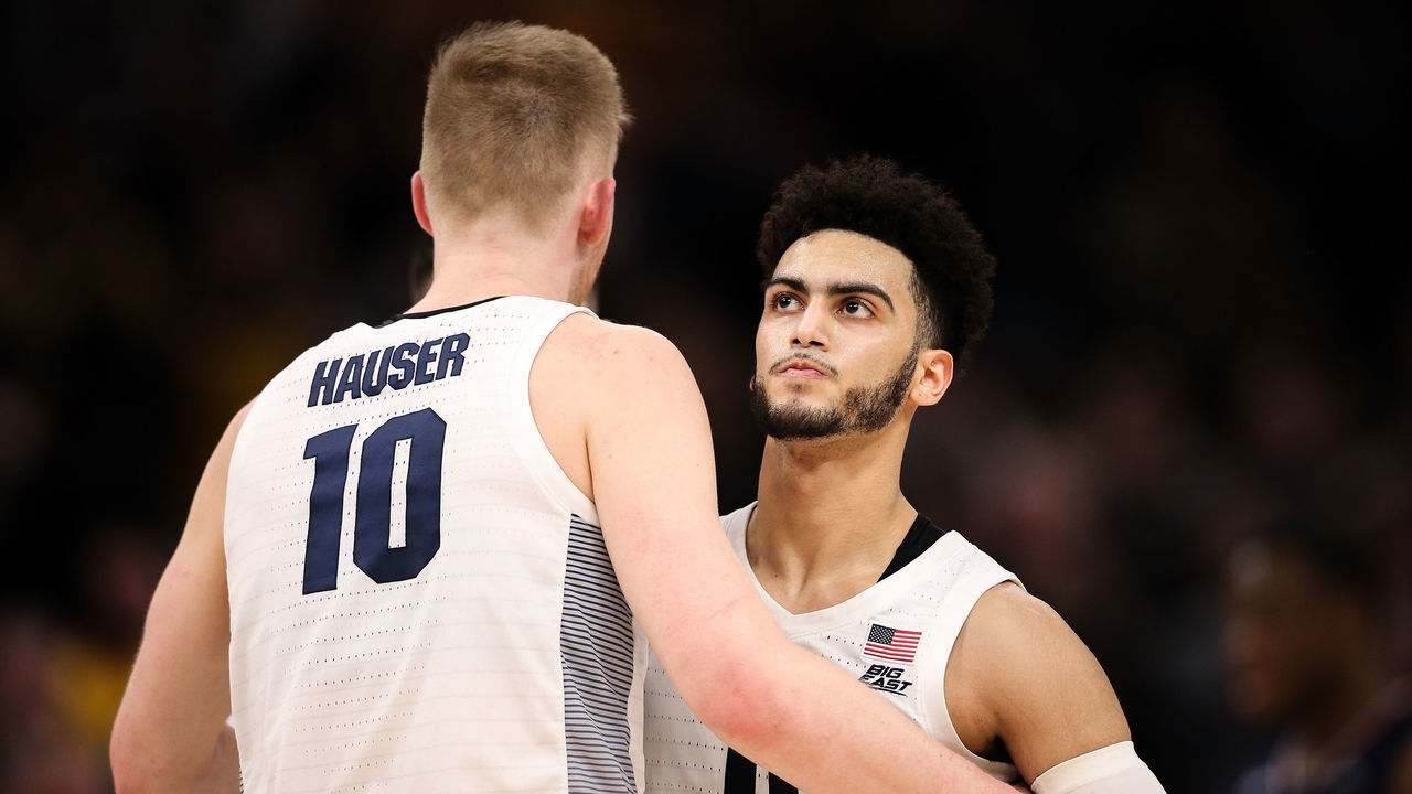 MILWAUKEE, WISCONSIN - FEBRUARY 05: Sam Hauser #10 and Markus Howard #0 of the Marquette Golden Eagles meet in the second half against the St. John's Red Storm at the Fiserv Forum on February 05, 2019 in Milwaukee, Wisconsin.