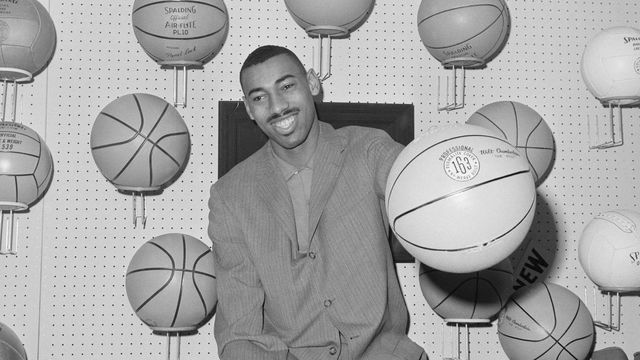 (Original Caption) Sporting Goods Fair. Manhattan, New York, New York: Wilt 'The Stilt' Chamberlain opens sporting goods fair at the Hotel New Yorker by palming new model basketball carrying his name.