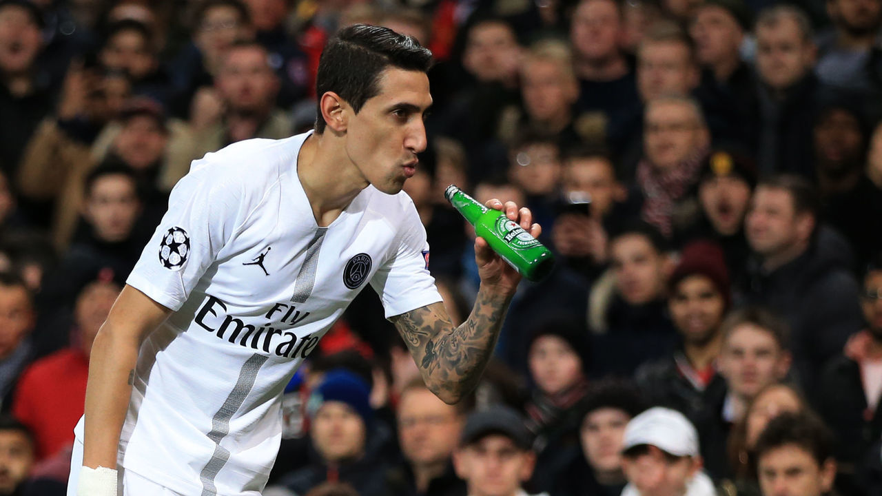 MANCHESTER, ENGLAND - FEBRUARY 12: Angel Di Maria of Paris Saint-Germain makes to drink from a bottle of beer thrown onto the pitch during the UEFA Champions League Round of 16 First Leg match between Manchester United and Paris Saint-Germain at Old Trafford on February 12, 2019 in Manchester, England.