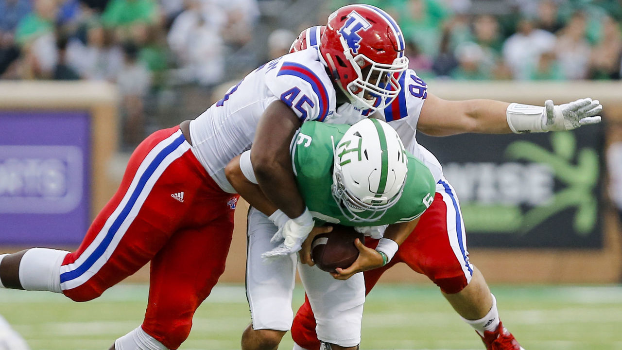 DENTON, TX - SEPTEMBER 29: North Texas Mean Green quarterback Mason Fine (6) gets sacked by Louisiana Tech Bulldogs defensive end Jaylon Ferguson (45) during the game between the North Texas Mean Green and the Louisiana Tech Bulldogs on September 29, 2018 at Apogee Stadium in Denton, Texas.