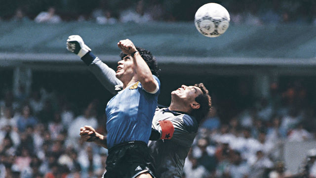 MEXICO CITY, MEXICO - JUNE 22: Diego Maradona of Argentina uses his hand to score the first goal of his team during a 1986 FIFA World Cup Quarter Final match between Argentina and England at Azteca Stadium on June 22, 1986 in Mexico City, Mexico. Maradona later claimed that the goal was scored by 'The Hand Of God'.
