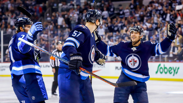 WINNIPEG, MB - FEBRUARY 16: Ben Chiarot #7, Tyler Myers #57 and Brandon Tanev #13 of the Winnipeg Jets celebrate a first period goal against the Ottawa Senators at the Bell MTS Place on February 16, 2019 in Winnipeg, Manitoba, Canada.